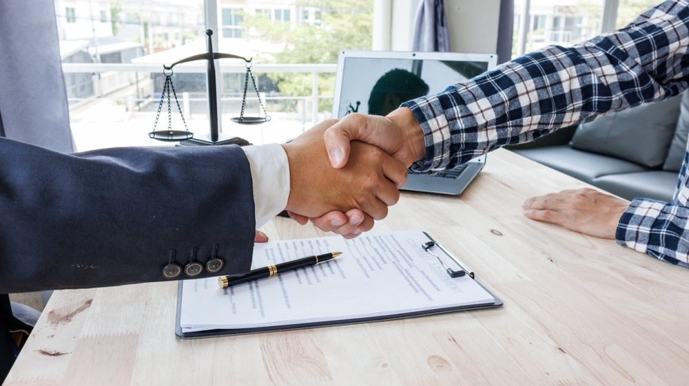 client and criminal defense lawyer shaking hands